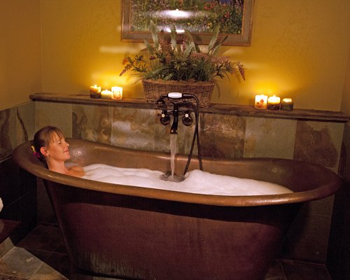 A woman relaxing in the bathtub with shower.
