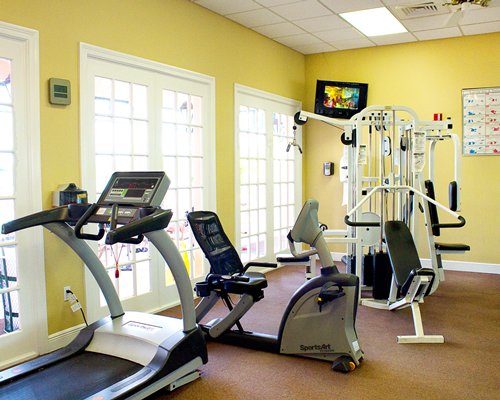 A well equipped fitness center with television.