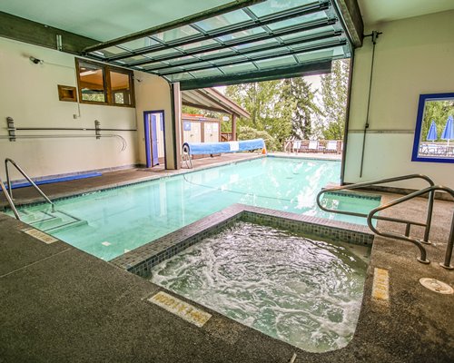 A large indoor swimming pool with patio furniture.