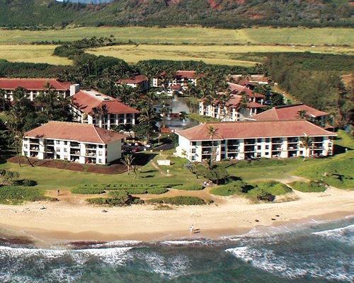 Scenic exterior view of MROP at Kauai Beach Villas alongside the beach.