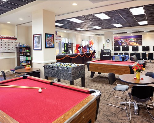 An indoor recreational room with two pool table and soccer table.
