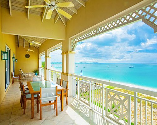 Outdoor dining in a balcony with a view of the beach.
