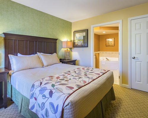 A well furnished bedroom with a king bed and mirror.