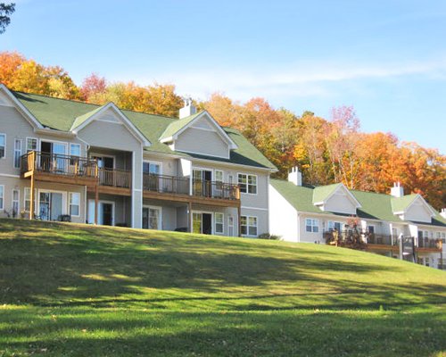 Scenic exterior view of multi story resort units surrounded by trees.