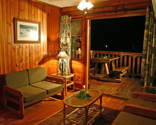 A well furnished living room with balcony and outdoor dining.