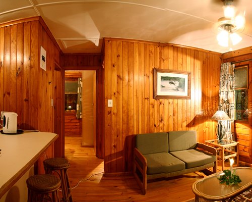 A well furnished living room alongside kitchen with a breakfast bar.