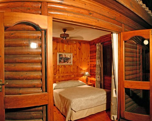 A wood themed bedroom with a lamp.