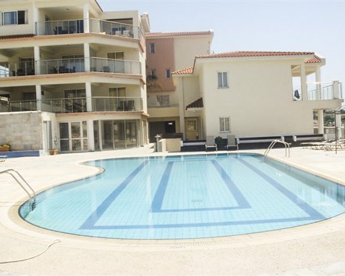 An outdoor swimming pool alongside the multi story condo.