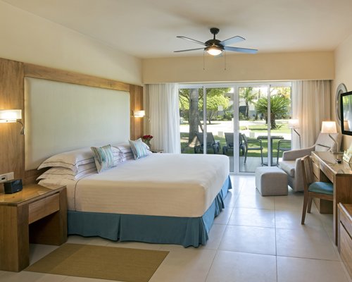 A well furnished bedroom with a queen bed and outside view.
