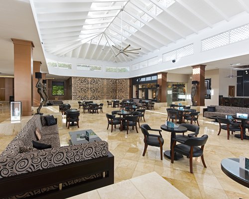 A large well furnished lobby with tables and chairs.