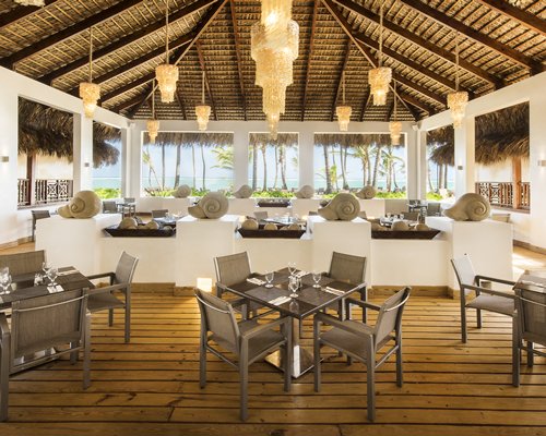 A restaurant with open windows and ocean view.