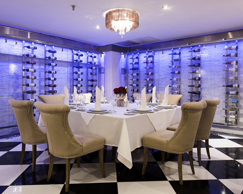 A restaurant interior with large table with wall wine racks.