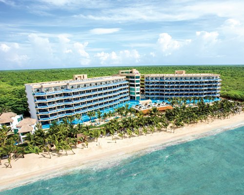 Exterior view of El Dorado Seaside Suites a Gourmet Inclusive Resort alongside the beach.