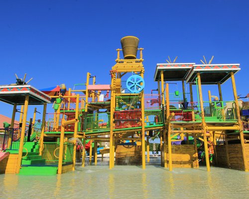 The water park with mushroom umbrella and chaise lounge chairs.