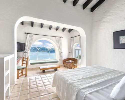 A well furnished bedroom with a king bed and the beach view.