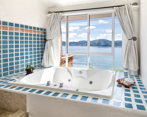 A bathroom with a bathtub with ocean view.