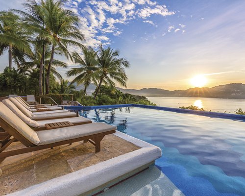 An outdoor swimming pool with chaise lounge chairs.