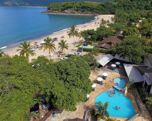 An aerial view of outdoor swimming pool and hot tub alongside the beach.
