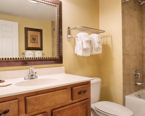 A bathroom with a bath tub shower stall and closed sink vanity.