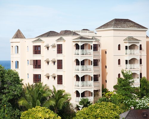 An exterior view of multi story resort condos surrounded by trees.