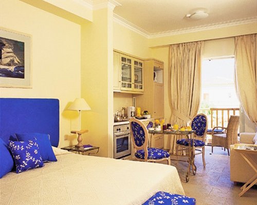 An open plan bedroom and dining area with an outside view.