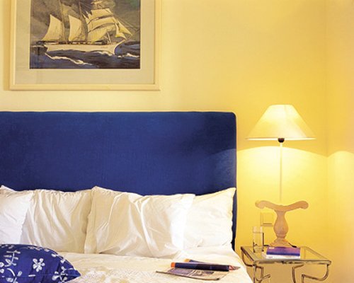 A well furnished bedroom with a lamp.