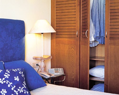 A well furnished bedroom with telephone and a lamp.