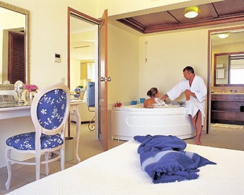 A well furnished bedroom with couple bathing in a hot tub.