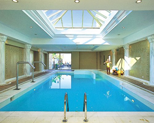 An indoor swimming pool with an outside view.