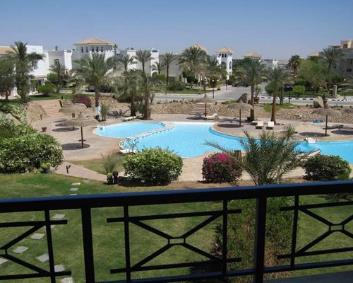 View of multiple unit balconies with outdoor swimming pool and sunshades.