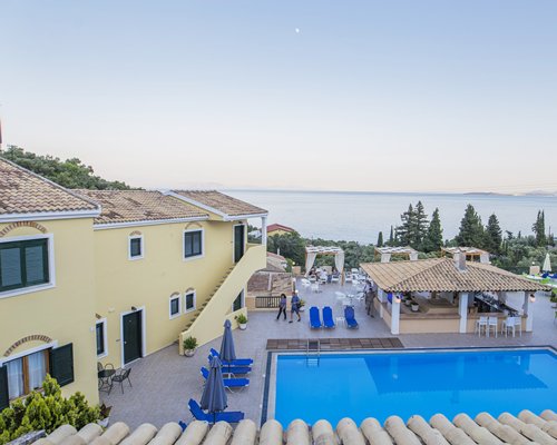 A balcony view of an outdoor swimming pool and a poolside bar.