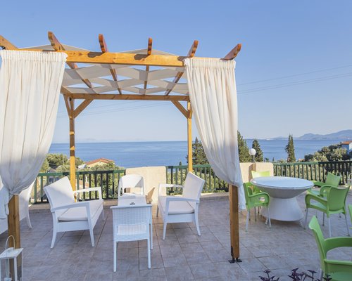 A balcony with patio furniture alongside the sea.