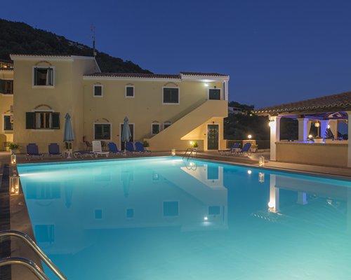 A night view of an outdoor swimming pool alongside Corfu Residence resort.