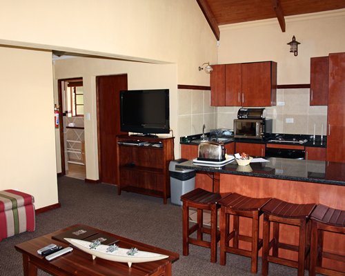 A well furnished kitchen with sink and micro oven alongside a television.