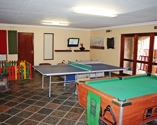 An indoor recreational area with a pool table and a ping pong table.