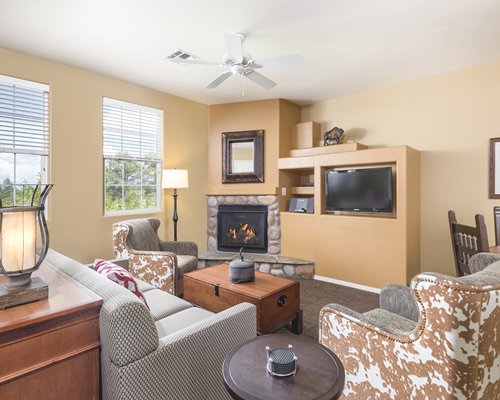 A well furnished living room with a television fireplace dining area and outside view.
