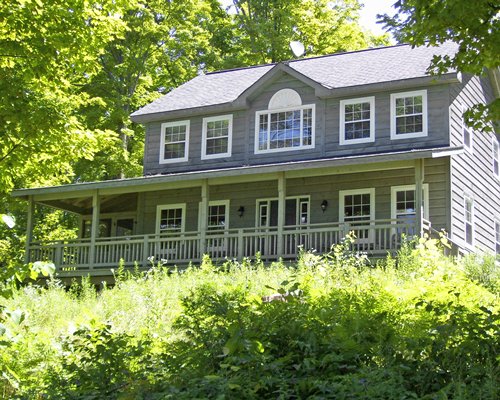 Exterior view of a unit with balcony at William's Landing surrounded by wooded area.