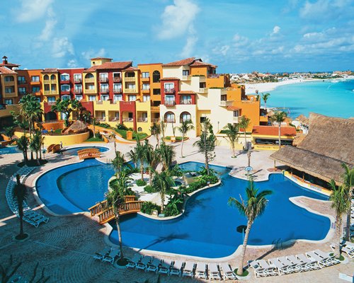 An aerial view of the outdoor swimming pool with chaise lounge chairs alongside the resort.