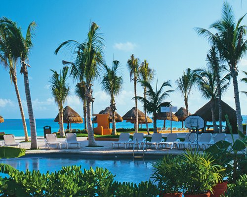 Outdoor swimming pool with a variety of shaded lounge areas.