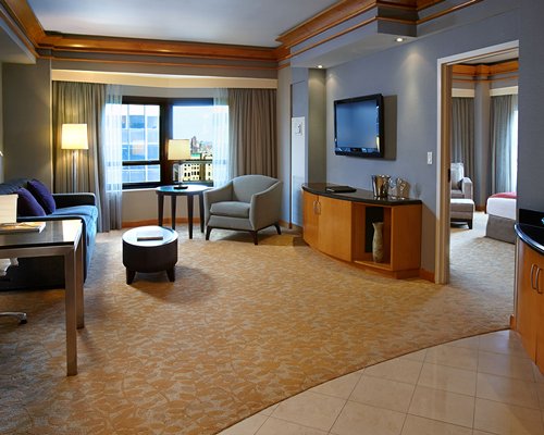 A well furnished living room with television and view of bedroom.