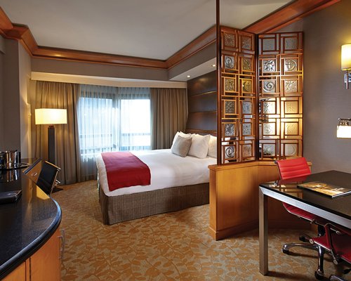 A well furnished bedroom with king bed and outdoor view.