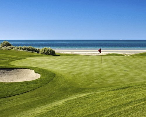 A well manicured golf course alongside the beach.