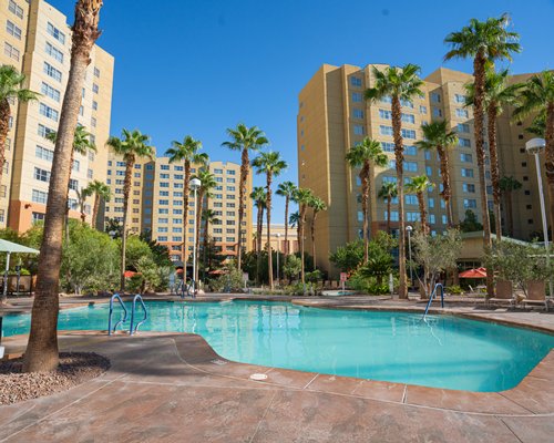 Exterior view of the resort with outdoor swimming pool and chaise lounge chairs.