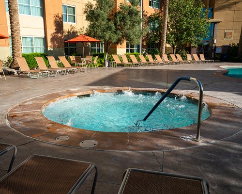 An outdoor swimming pool with trees alongside the resort.