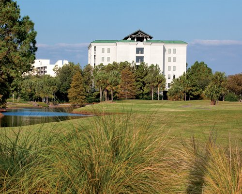 Exterior view of Wyndham Bay Club surrounded by wooded area alongside the lake.
