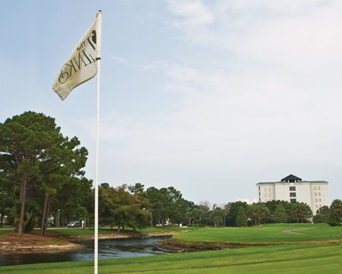 Golf course with flag alongside the water.