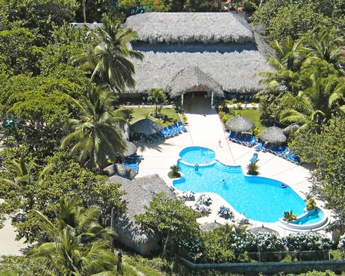 An exterior view of the resort with a swimming pool and hot tub surrounded by the trees.