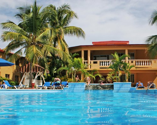 An outdoor swimming pool with chaise lounge chairs alongside the resort.