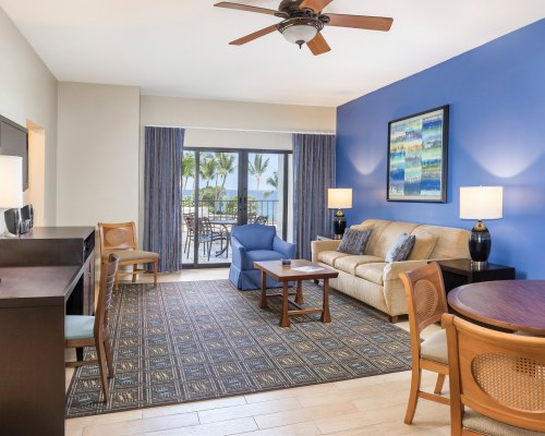 A WELL FURNISHED LIVING ROOM WITH A TELEVISION ALONGSIDE THE PATIO.