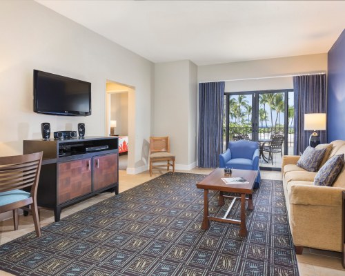 A WELL FURNISHED LIVING ROOM WITH QUEEN PULL OUT SOFA TELEVISION AND PATIO.